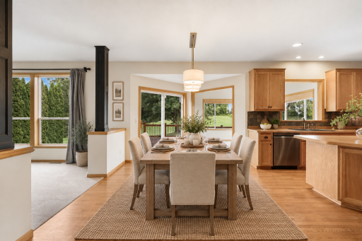 The spacious informal dining area is filled with natural light and opens directly to the deck, offering the perfect setting for everyday meals and effortless indoor-outdoor entertaining. Virtual staging.