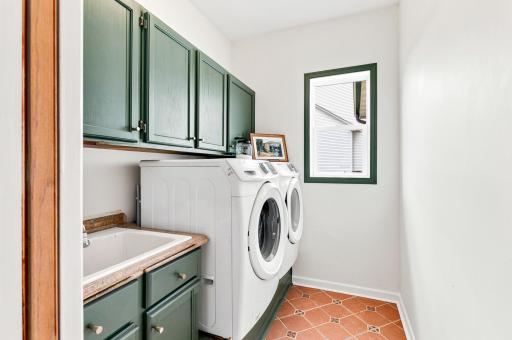 Convenient main-level laundry room with utility sink, abundant cabinetry, and plenty of space to keep everyday tasks organized.
