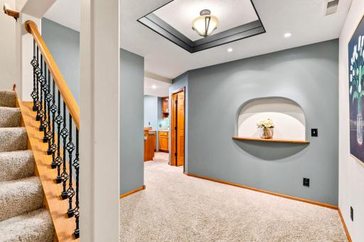 The inviting lower-level landing showcases elegant architectural details, custom display niche, and a warm, welcoming transition into the beautifully finished lower level.