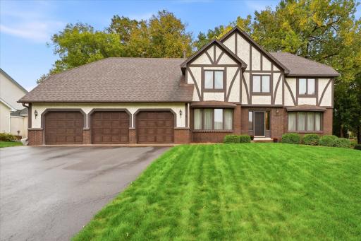 Impressive two-story home featuring distinctive Tudor-style architecture, mature trees, beautiful landscaping, and a spacious three-car garage.