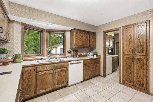 Generously sized kitchen offers abundant cabinetry and counter space, a large window overlooking the backyard, and convenient pantry storage.