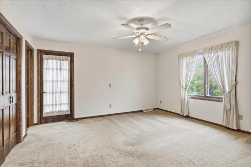 Another view highlights the spacious layout, ample closet space, and private access to the upper-level balcony.