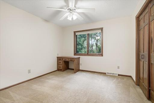 Bedroom #3: Bright upper-level bedroom offers a ceiling fan, neutral finishes, generous closet space, and a built-in desk beneath the window.