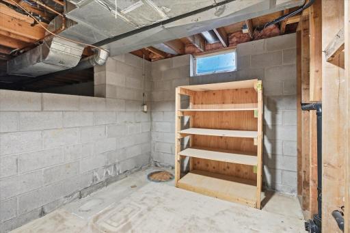Additional unfinished lower-level space offers plenty of potential for storage, shelving, or a workshop area.