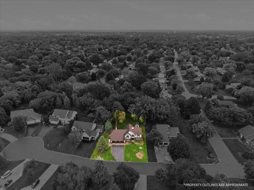 Aerial view showcasing the home and approximate property area surrounded by mature trees and neighboring homes.