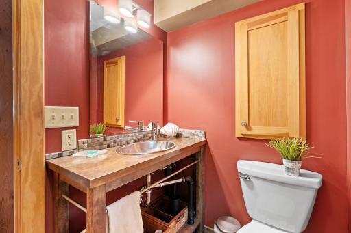 Lower-level bath with warm finishes and a custom wood vanity.