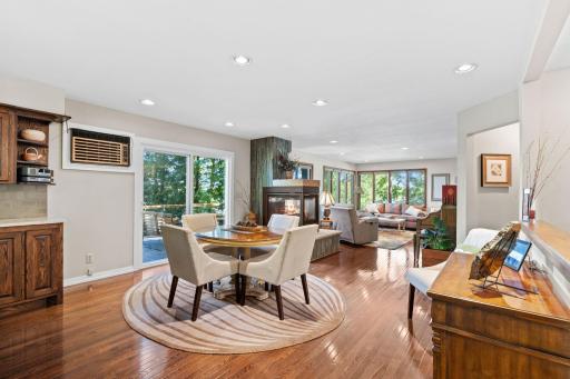 The dining area sits between the kitchen, living room, fireplace, and lakeside deck.