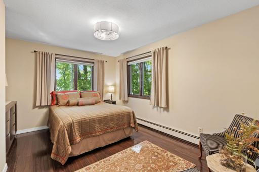 Windows on two sides bring plenty of light into this main-level bedroom.