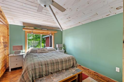 The Guest Suite bedroom carries through the vaulted ceiling and warm wood details.