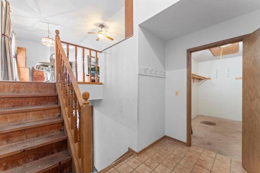 This is the entrance from the garage. Looking to the stairs leading to the family room, the stairs leading to lower level and the large storage closet