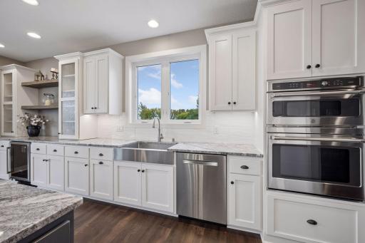 Generous cabinets with granite countertops, double wall oven, Bosch dishwasher, farmhouse sink, and wine fridge.