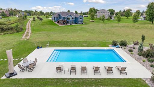 Pool view to house showing grandfathered-in gravel driveway that can potentially be used for a future pool house or shed