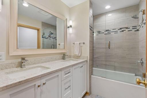 Upper level bath with dual sinks and ceramic tile tub surround.