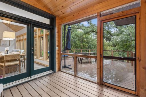 Knotty pine sunroom with vaulted ceilings walks out to the large deck.