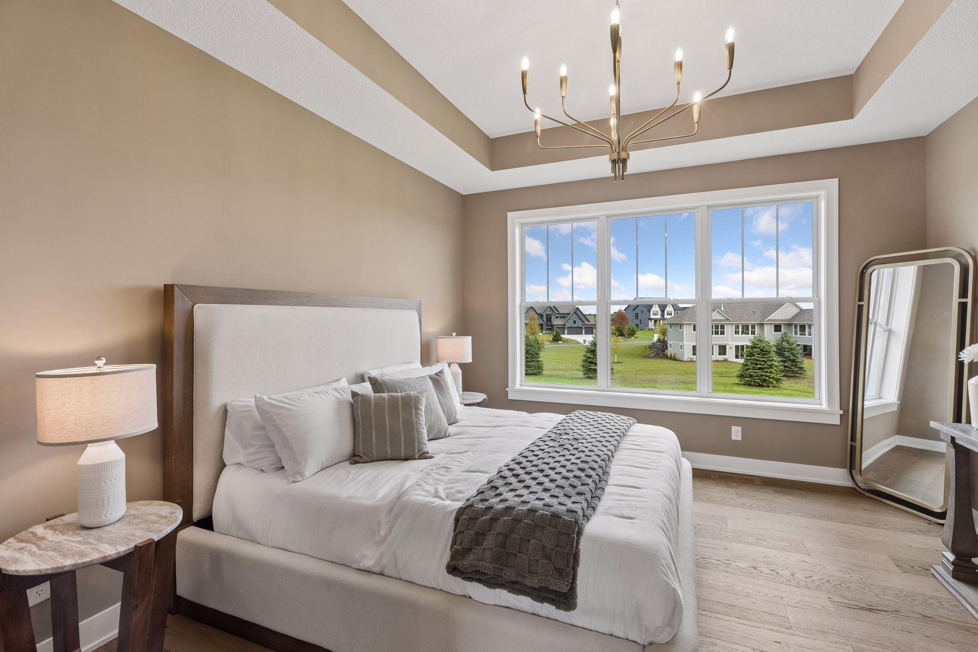 Main floor primary with natural views and tray ceilings