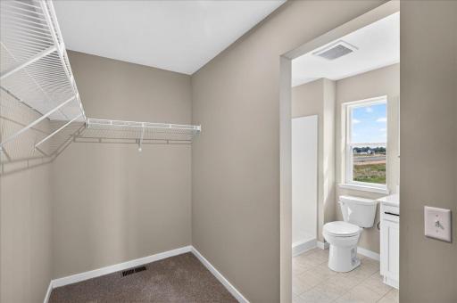 PHOTO OF A DIFFERENT HOME WITH SIMILAR PLAN AND FINISHES. Primary Suite Walk-in Closet.