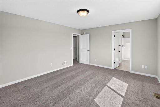 PHOTO OF A DIFFERENT HOME WITH SIMILAR PLAN AND FINISHES. Primary Suite features a Walk-in Closet and Private Bathroom.