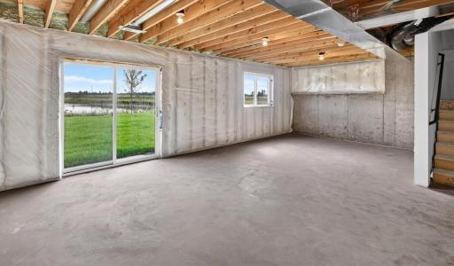 PHOTO OF A DIFFERENT HOME WITH SIMILAR PLAN AND FINISHES. Unfinished Walkout Lower Level.