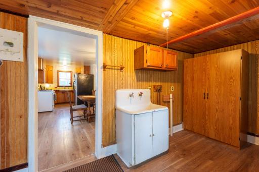 The main entrance mudroom with utility sink and space for a washer & dryer setup.