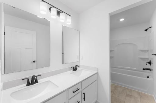 This full bathroom is conveniently located on the second floor and showcases dual sinks and a shower-tub combination.