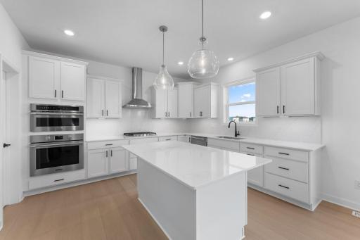 This stylish kitchen showcases a large center island, Shaker-style cabinetry, and brand-new stainless-steel appliances.