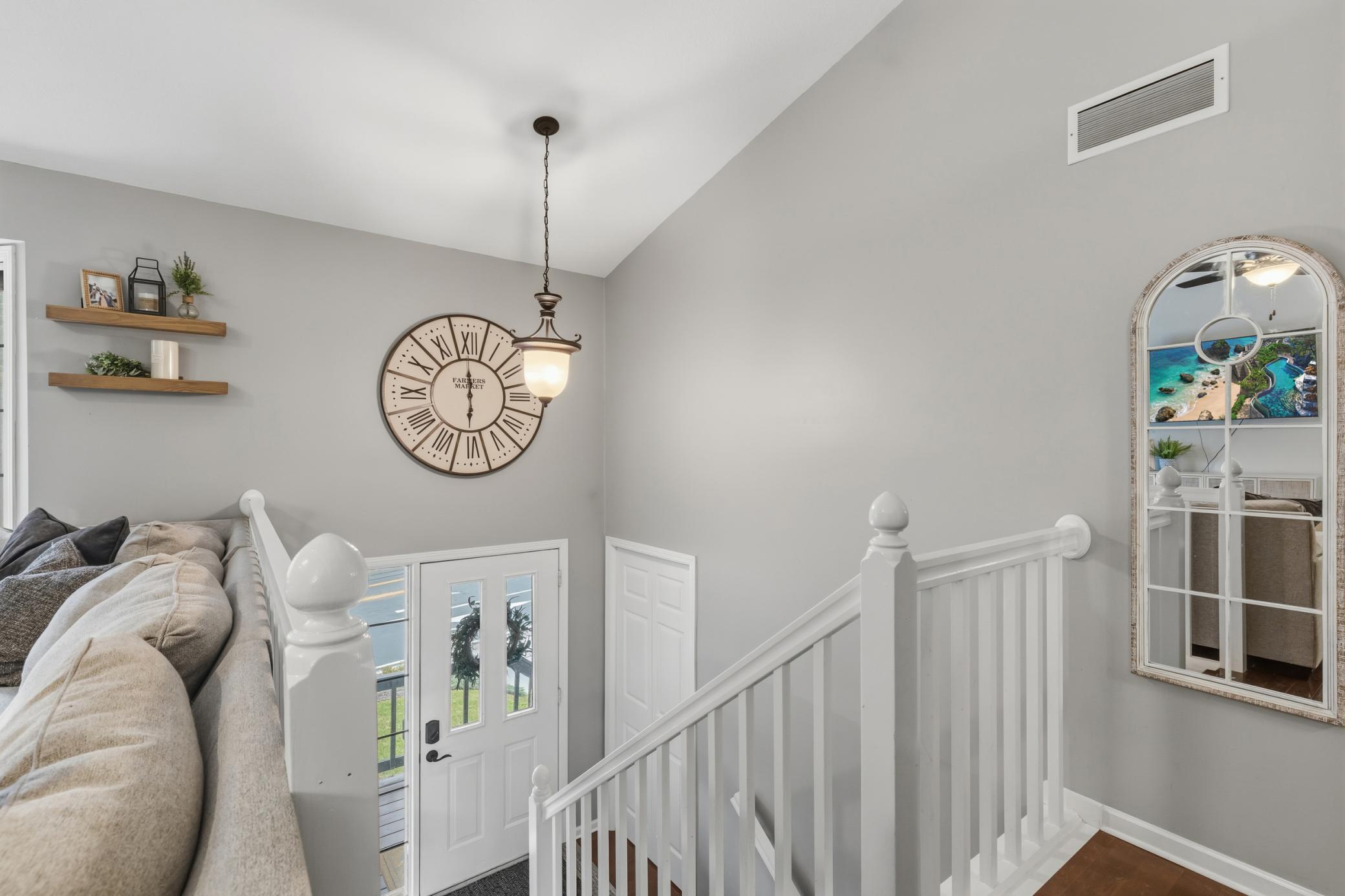 Foyer features open staircase that offers enameled railings and maple hardwood treads. Vaulted ceilings