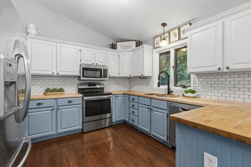 Kitchen offers enameled cabinetry that features raised panel doors, pantry and a breakfast counter.