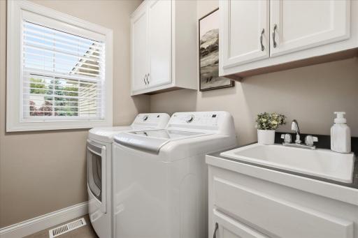 Main-level laundry room with ample cabinetry for additional storage
