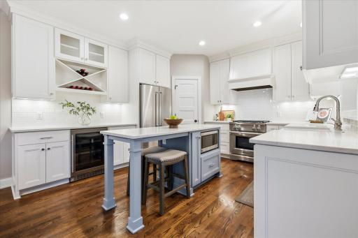Beautifully renovated kitchen with custom cabinetry, quartz countertops & large center island