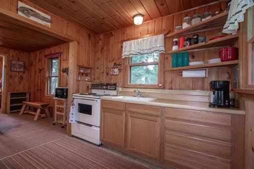 To the right is a wall of cabinets and kitchen window. LOTS of natural woodwork!