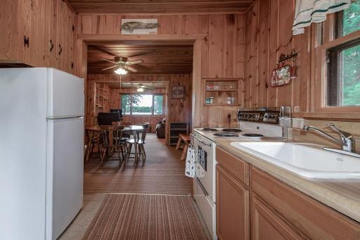 Enter the cabin to this classic cabin kitchen looking out over the dining area and living area to the lake beyond!