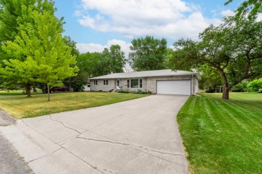 Long concrete driveway with extra off-street parking, framed by mature trees