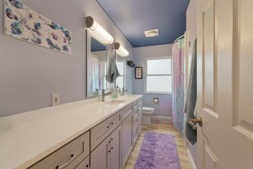 Full bathroom with extended vanity, ample drawer storage, and window for natural light