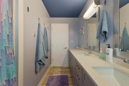 Bathroom with dual-sink vanity, long countertop, and vanity lighting