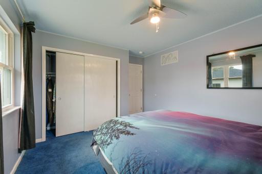 Primary bedroom with double-door closet and ceiling fan