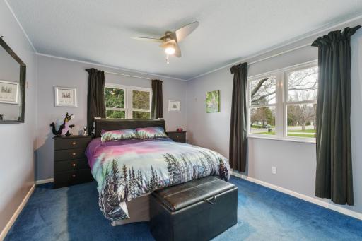 Primary bedroom with windows on two walls, ceiling fan, and room for a king-size setup