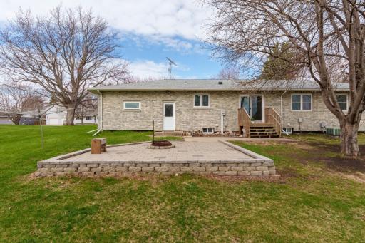 Raised block patio with fire pit, back entry, and steps to the rear door