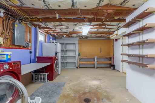 Utility and laundry room with washer and dryer, workbench, open shelving, and extra storage space