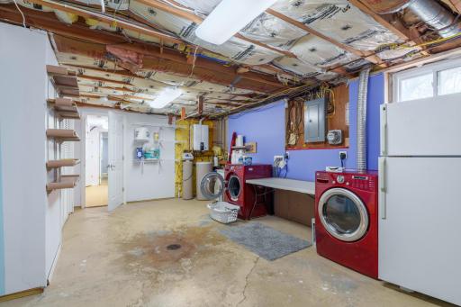 Laundry and utility area with front-load washer and dryer, water heater, and room for storage