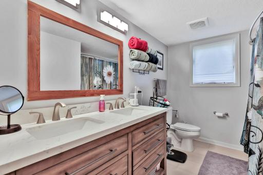 Walk thru primary bath with double sinks.
