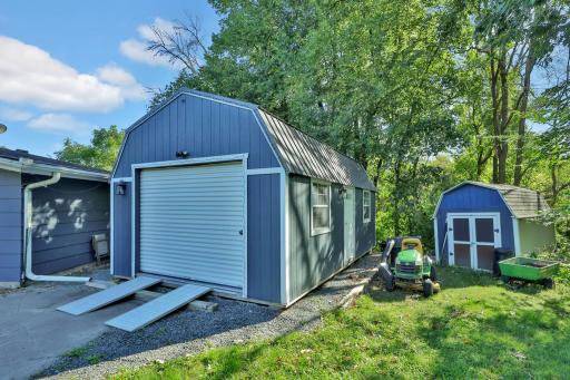 Nice sized storage shed with roll up door and additional garden shed to the right.