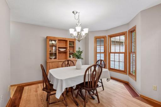 Light-filled formal dining room with hardwood floors and beautiful bay windows