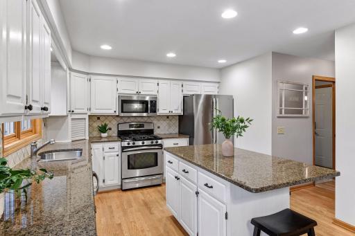 Spacious kitchen featuring granite countertops, stainless steel appliances, abundant cabinetry and a large center island