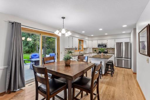 Bright, open kitchen and informal dining area with hardwood floors and views of the backyard