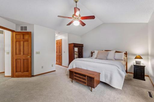 Spacious upper-level primary bedroom with vaulted ceiling and plenty of natural light