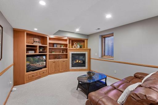 Expansive lower-level family room featuring built-in cabinetry and a cozy gas fireplace
