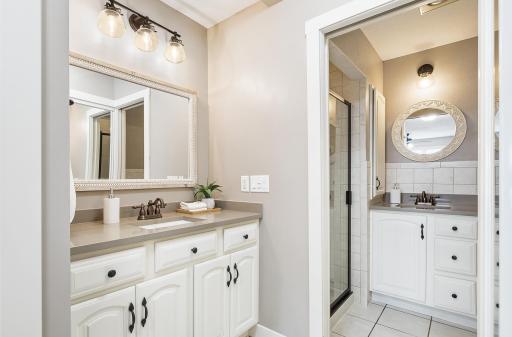 Primary bathroom with walk-in shower and 2 vanities.
