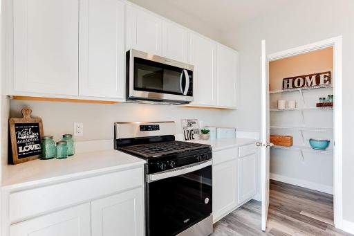 Stainless steel appliances and a pantry in this wonderful kitchen.