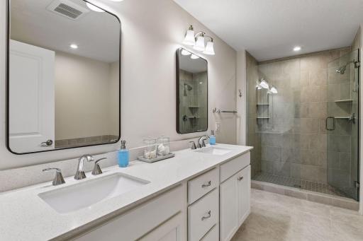The Primary Bathroom offers a comfort-height vanity with quartz countertops, a large soaking tub and a tiled shower with glass enclosure.