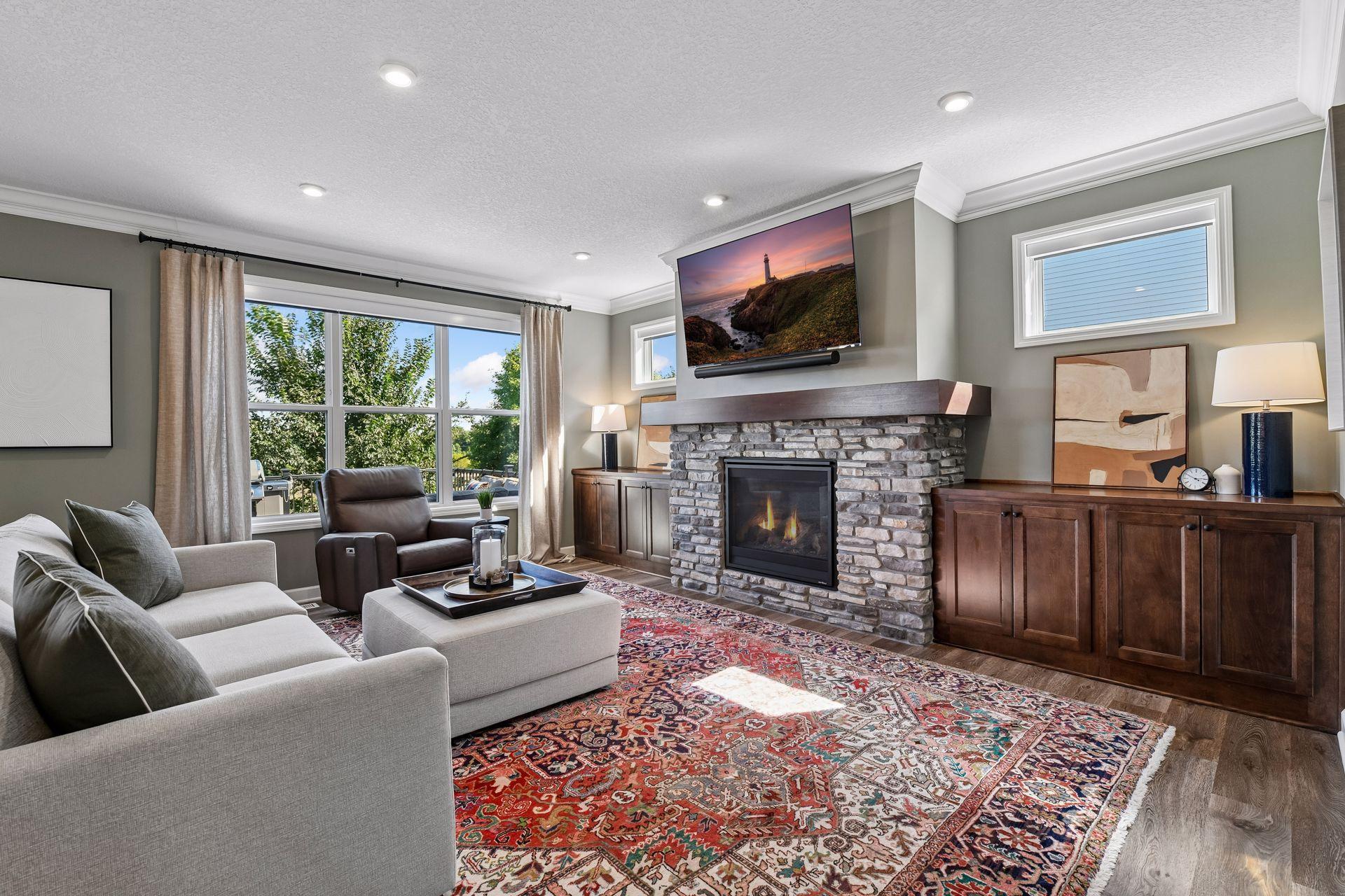 A gas fireplace and stone surround create a natural focal point, complemented by built-in cabinetry on either side.